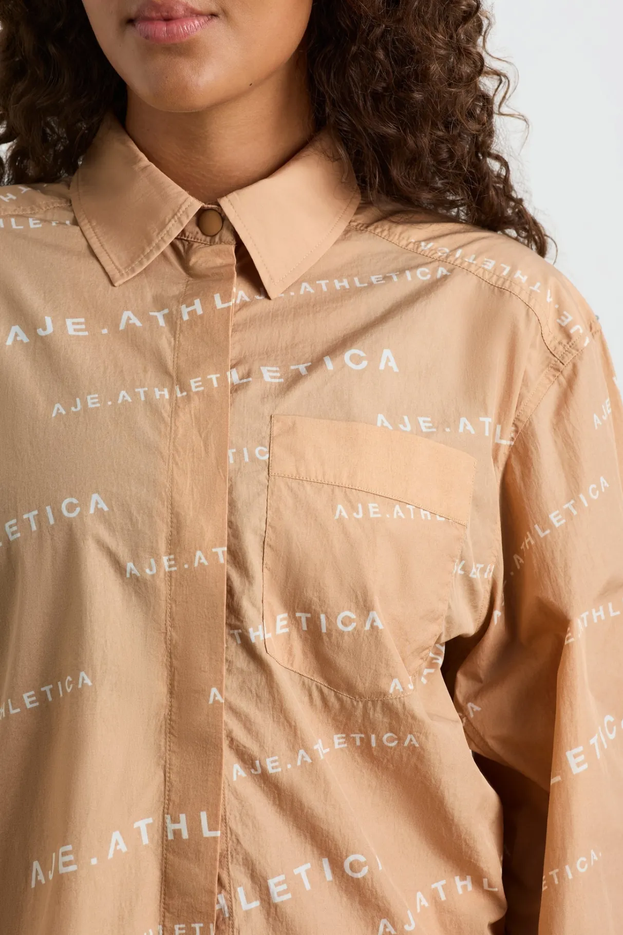 all_over_logo_spray_shirt__10-1.webp Shop Aje ATHLETICA All Over Logo Spray Shirt 406 Natural Tan / White