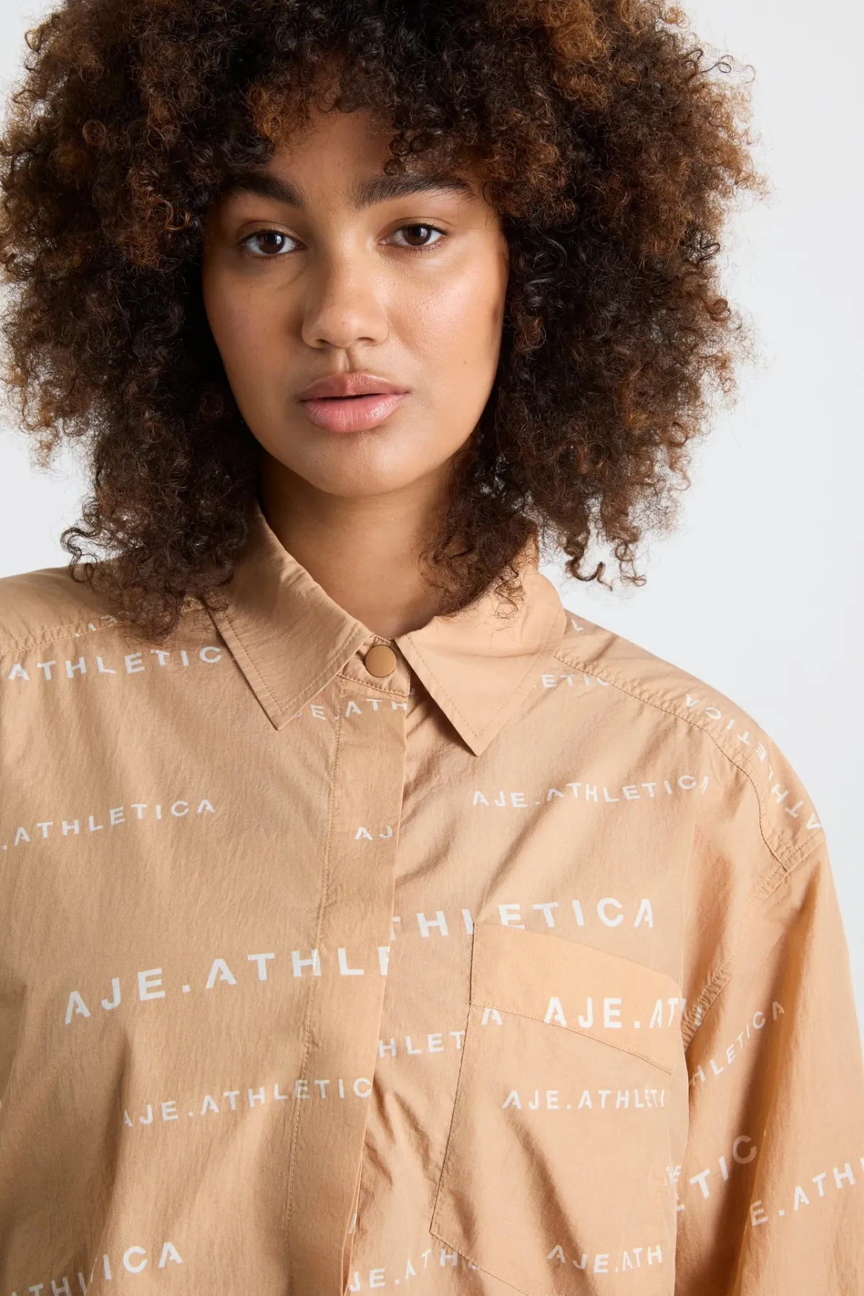 all_over_logo_spray_shirt__14-1.webp Shop Aje ATHLETICA All Over Logo Spray Shirt 406 Natural Tan / White